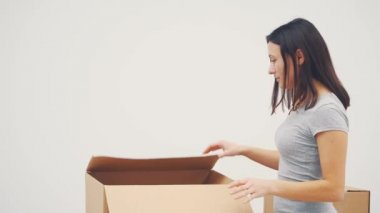 Hevesli kadın kutuları açıyor, beyaz saati çıkarıp nereye asacağını düşünüyor..