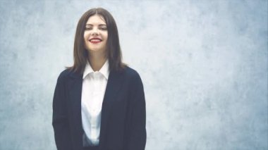 Siyah takım elbiseli, gülümseyen iş kadını umutsuzca konuşuyor, yan tarafa bakıyor..