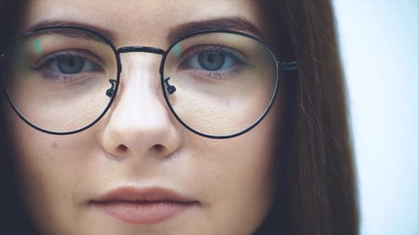 Abgeschnittenes Gesicht einer attraktiven Geschäftsfrau mit Brille, die in die Kamera blickt, lieblich lächelnd. — Stockvideo