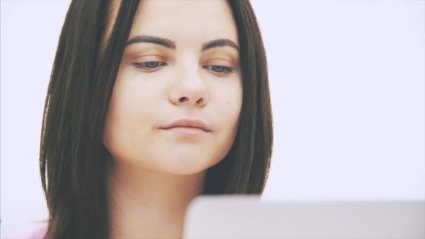Симпатична біла брюнетка дівчина з ноутбуком, серфінг в Інтернеті, кивнула головою . — стокове відео