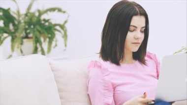 Kanepede dizüstü bilgisayarıyla oturan, internette sörf yapan, duygusal bir şeye tepki veren, son derece heyecanlı görünen esmer kız..