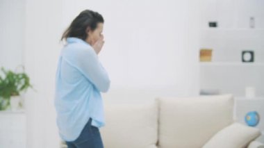 Yorgun esmer kadın kanepeye uzanacak. Esniyor ve uyumak istiyor. 4k.