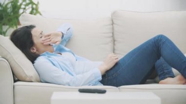 Uykulu, güzel bir kadın uyanıyor ve televizyon izlemeye başlıyor. Televizyonu elektrik şokuyla açıyor. Ekin. Uzayı kopyala 4k.