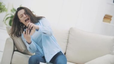 Çekici esmer kadın telefon oyununa bulaşmış. El sallıyor, seviyeyi geçmeye çalışıyor. Uzayı kopyala 4k.