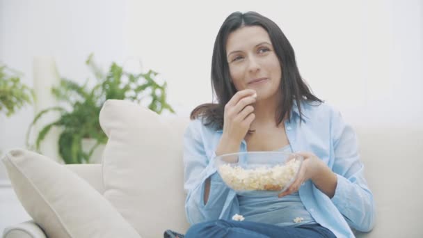 Primer plano de la mujer morena, que está masticando maíz pop. Delicioso-delicioso. Copiar espacio. 4K . — Vídeos de Stock