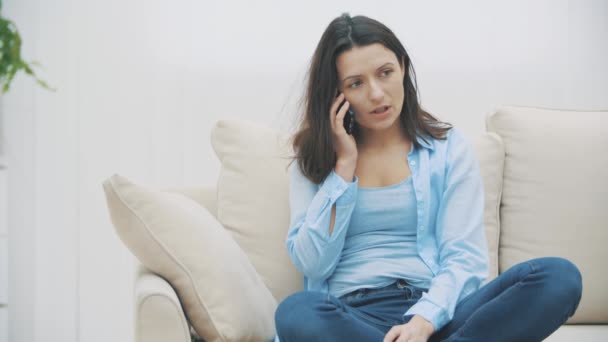 Primo piano della donna attraente in camicia blu, che sta parlando al telefono, mentre seduto a casa. Al rallentatore. Ricevuto. 4K . — Video Stock