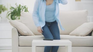Yavaş ol. Genç kadın kanepeye düştü ve televizyon izlemeye başladı. Kapatın. 4k.
