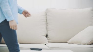 Yavaş ol. Genç kadın kanepeye düştü ve televizyon izlemeye başladı. Kapatın. 4k.