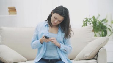 Takdire şayan kadın akıllı telefonunu kullanıyor. Aniden kanepeden kalktı ve aceleyle uzaklaştı. Ağır çekim. Uzayı kopyala 4k.