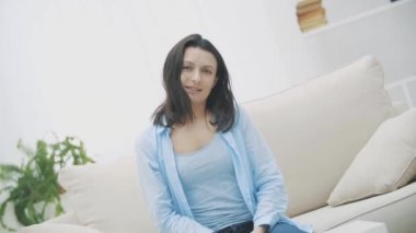 Güzel, sevimli ve komik bir kadın gülümsüyor ve iyi hissediyor. Komik kadın beyaz arka planda izole edilmiş bir dil gösteriyor. Ağır çekim. 4k.