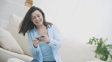 Çekici esmer kadın telefon oyununa bulaşmış. El sallıyor, seviyeyi geçmeye çalışıyor. Kadın başarısız olacak. Ağır çekim. Uzayı kopyala 4k.