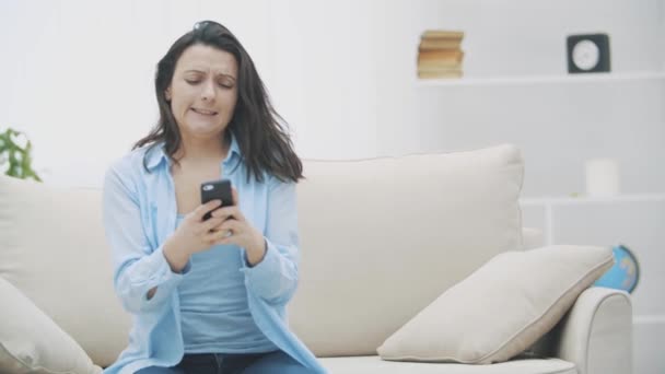 Aantrekkelijke brunette vrouw is betrokken bij het telefoonspel. Ze zwaait, probeert door het level te komen. Langzame beweging. Begrepen, ruimte. 4k. — Stockvideo