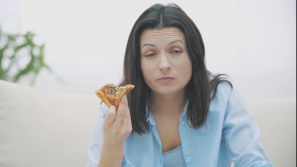 Slowmo. Close up of adorable woman, who is chewing a piece of pizza and shifting emotions. Yummy-yummy. 4K. — ストック動画