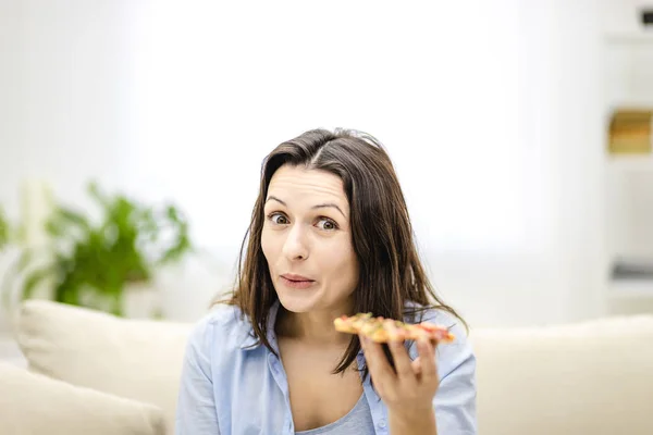 Brunette γυναίκα είναι θετικά σοκαρισμένος πόσο νόστιμη πίτσα είναι, και σηκώνει τα φρύδια της επάνω. Κλειστό.. — Φωτογραφία Αρχείου