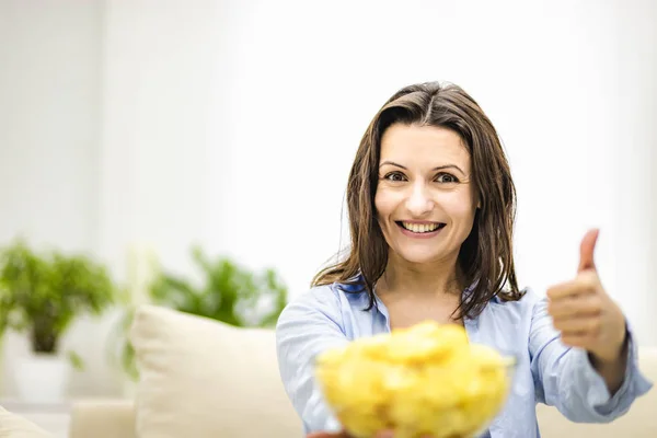 Feliz adorável morena mulheres mostra uma grande placa profunda com batatas fritas lanche e seu polegar para cima . — Fotografia de Stock