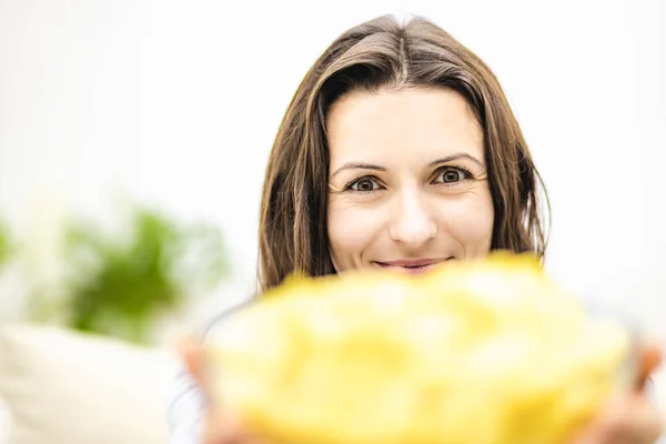 Feliz adorable morena ofrece un plato grande y profundo con papas fritas snack. Frontera borrosa . —  Fotos de Stock