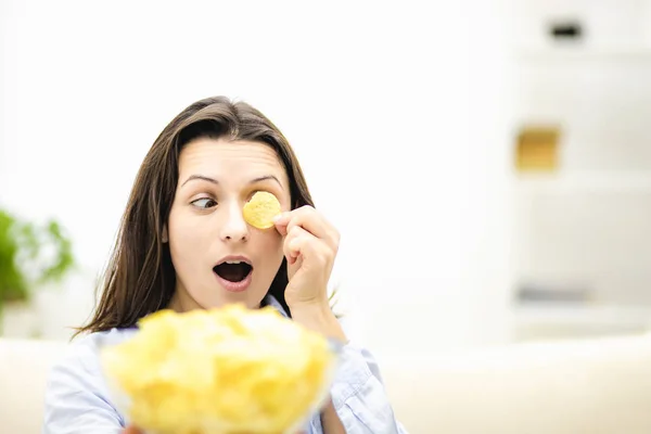 Geschokt brunette vrouwen sluit haar oog met chips snack, geïsoleerd, op witte achtergrond. Sluiten.. — Stockfoto