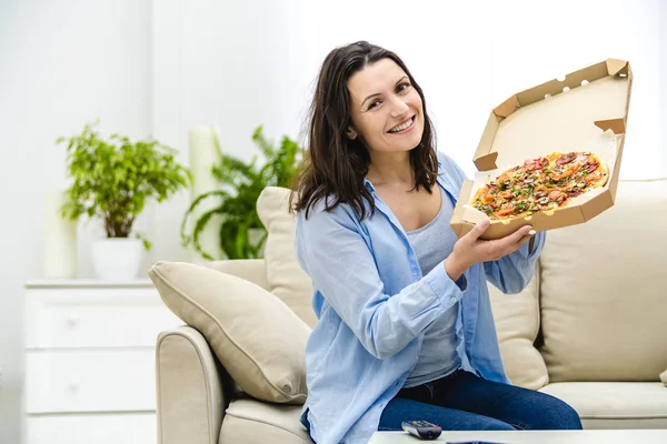 Mooie en gelukkige vrouw eet pizza. Ze glimlacht oprecht. Echt waar. Begrepen, ruimte. Sluiten.. — Stockfoto