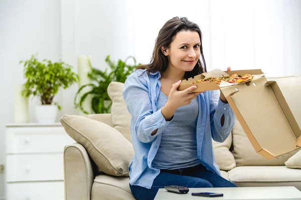 Vacker och lycklig kvinna äter pizza. Hon ler uppriktigt. Uppfattat utrymme. Närbild. — Stockfoto