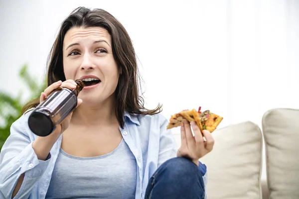 Brunette is bang vanwege tv-programma 's. Ze is gestrest. De vrouw probeert haar pijn te genezen met behulp van snacks. Sluiten.. — Stockfoto