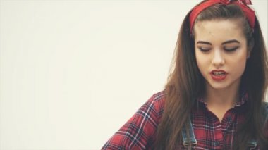 Tatlı, baştan çıkarıcı kız ağzını karpuz lolipopun arkasına saklayıp kameraya baştan çıkarıcı bir şekilde bakıyor, şekerini tadıyor..