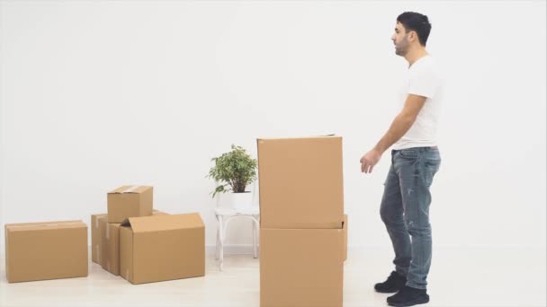 El hombre está entrando en una habitación. Está buscando a su esposa. De repente, salta de las cajas. Son felices y se abrazan. 4K . — Vídeos de Stock