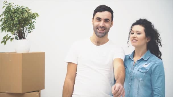 若いカップルが一緒に新しいアパートに移動しています。笑顔のカップル。閉めろコピースペース4k. — ストック動画