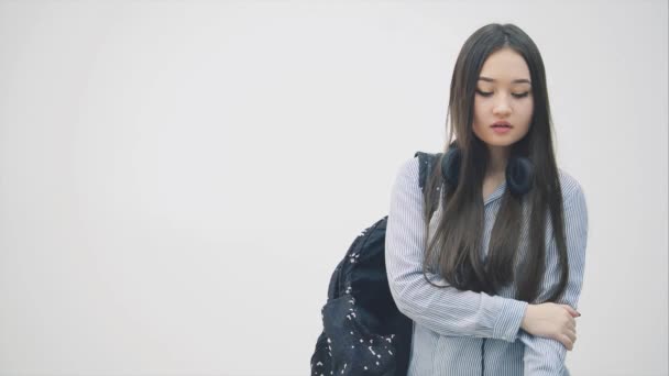 Молодая азиатская девушка с рюкзаком через плечо зовет кого-то, но не может связаться с ним, прячет телефон, выглядит сердитым и разочарованным . — стоковое видео