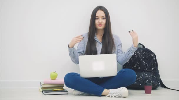 Ung asiatisk dam som sitter på golvet i lotos position, med bärbar dator, lyfta händerna med copyspace för text eller produkt, viktning. — Stockvideo