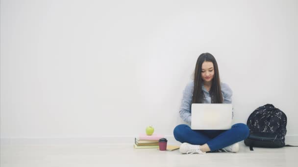 Asiatique dame assis sur le sol en position lotos, avec ordinateur portable, levant les mains, les agitant et souriant joyeusement comme un gagnant . — Video