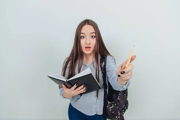 Periodista joven. Linda chica asiática joven de pie con cuaderno, señalando a alguien como si le diera un derecho a hablar. Mochila colgada sobre su hombro . — Foto de Stock