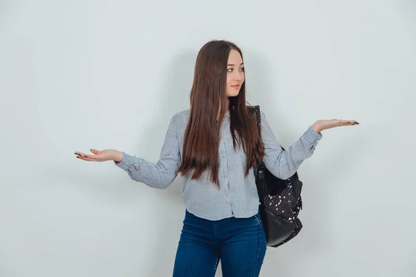 Inspirado joven asiática chica de pie con mochila colgada sobre su hombro, levantando sus palmas abiertas con copyspace para texto o producto . —  Fotos de Stock