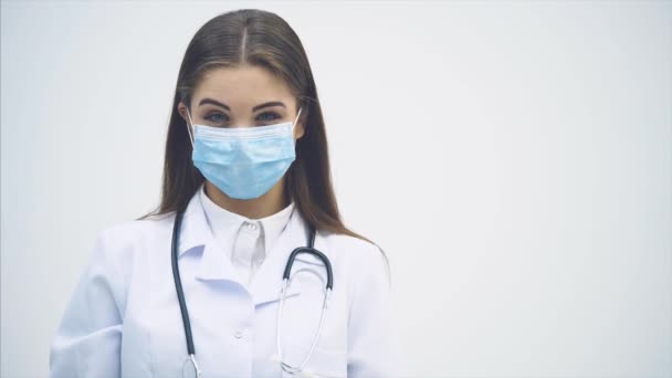 Crazy female doctor looking suspicious, holding big knife in her hand, waving it desparately, then attacking the video operator. — ストック動画