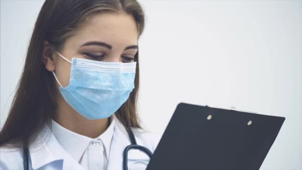 Pasante femenina joven de pie, sujetando el portapapeles, revisando los datos, asintiendo con la cabeza, levantando las cejas, abriendo los ojos ampliamente . — Vídeos de Stock