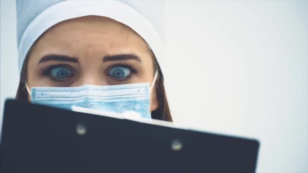 Adorabile medico donna ha letto alcune cattive notizie e sta guardando con paura e disperazione nei suoi occhi . — Video Stock