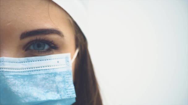 Cara media cara recortada de una linda interna femenina de pie, abriendo lentamente los ojos, mirando a la cámara con mirada penetrante. Pestañas largas, ojos azules . — Vídeos de Stock