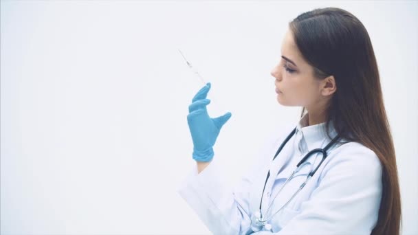 Medico professionista femminile in maschera e guanti che prepara siringa monouso una tantum con farmaco trasparente. Donna medico sul lavoro . — Video Stock