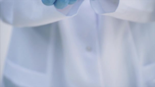 Многие маленькие белые таблетки в руках врачей одеты в медицинские одноразовые перчатки . — стоковое видео