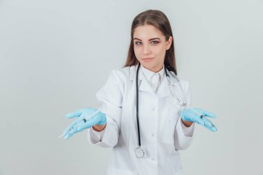 Gülümseyen genç bayan doktor kameraya avuçlarını şırıngalarla açıyor..