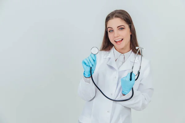 笑容满面的年轻医生举着听诊器，准备检查某个人. — 图库照片