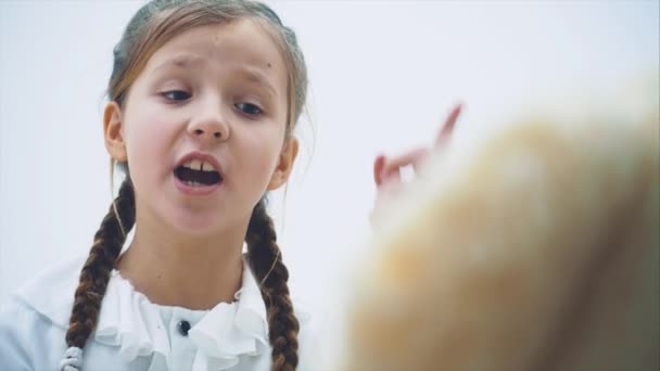 Schattig klein meisje zitten, praten met haar teddy, uitschelden, schudden haar vinger. — Stockvideo