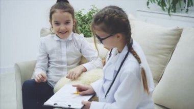 Oyuncak ayıyla oynayan iki tatlı çocuk. Bir kız boynunda steteskop olan bir doktor, diğeri de oyuncak ayı sahibi. Doktor ayılara teşhis koyuyor..