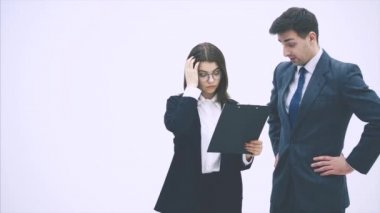 Kafası karışmış iş ortakları panoda üzerinde kağıt ve soru işareti olan bir kağıt tutuyorlar. Ne anlama geldiğini anlamıyorlar..