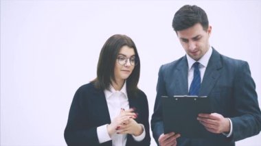 Kafası karışmış iş ortakları panoda üzerinde kağıt ve soru işareti olan bir kağıt tutuyorlar. Ne anlama geldiğini anlamıyorlar..