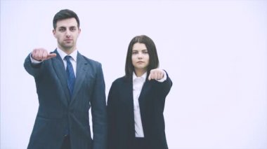 İş adamı ve kadın yan yana dururlar, ne yapacakları konusunda tereddüt ederler, başparmaklarını yukarı ya da aşağı kaldırırlar. Sonunda onaylamıyorlar, kaşlarını çatıyorlar, onaylamıyorlar..