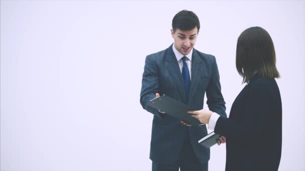 Cute office woman is reporting to her boss. But he is very strict, critisizes her, pointing at the clipboard. — Stock Video