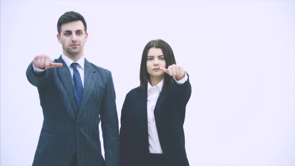 ビジネスの男性と女性の横に立って、何をすべきかを躊躇し、親指を上下に与える。最終的に彼らは親指を放棄し、笑顔で承認を表明しました. — ストック動画