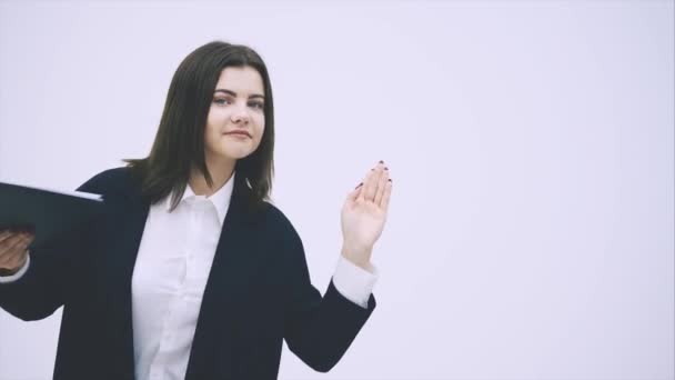 Pretty businesswoman standing with clipboard in her hands, moving hands comically, dancing, smiling. — Stock Video