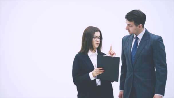 Pretty businesswoman standing with tablet in her hands, explaining something to her partner. Businessman on her side is listening, nodding. — 비디오