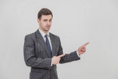 Başarılı yakışıklı iş adamı, bir proje sunuyor, metin ya da ürün için parmaklarını telif alanına doğrultuyor..